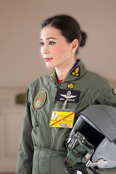 Queen Suthida in a Royal Thai Air Force flight suit holding a flight helmet
