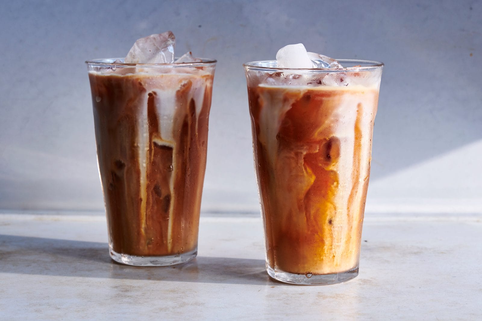 Cha yen — Thai iced tea in a plastic cup with condensed milk swirl