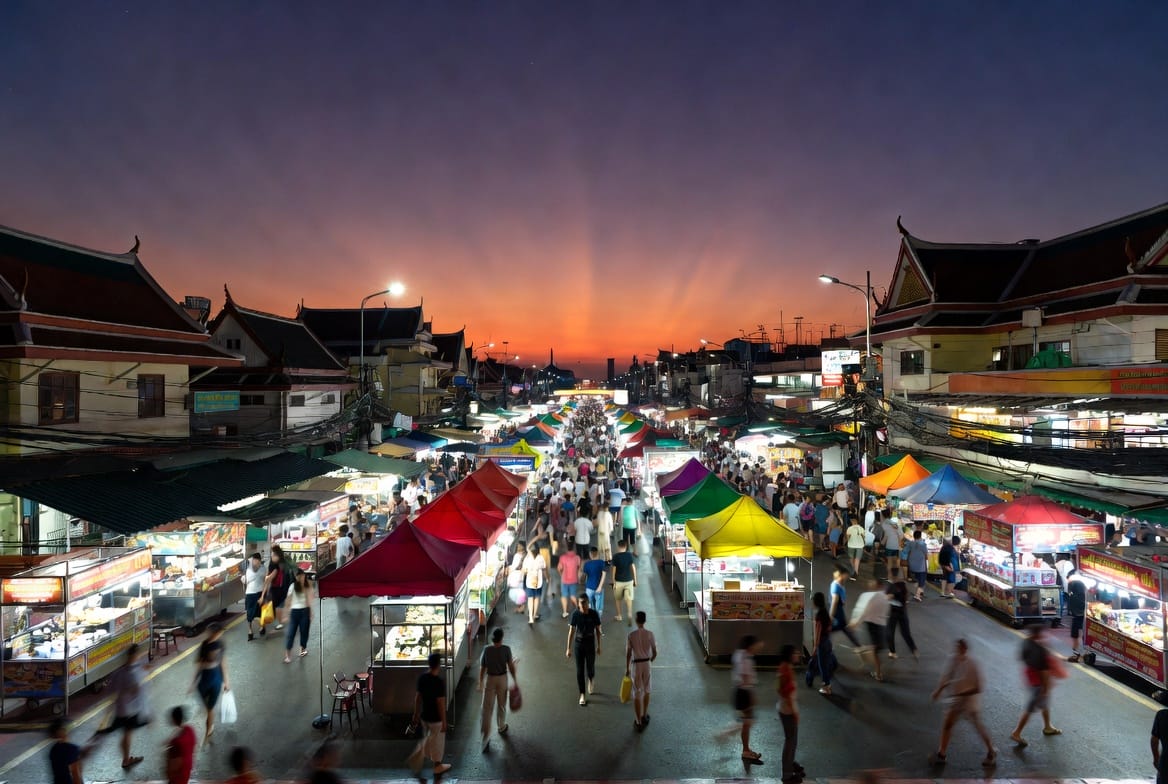 A large open night market glowing at dusk near Ramkhamhaeng