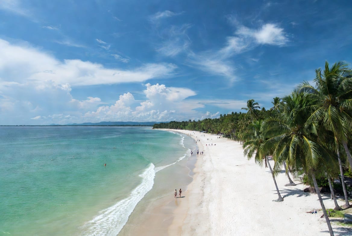 Long white sand Chaweng Beach on Koh Samui with turquoise water and palm trees