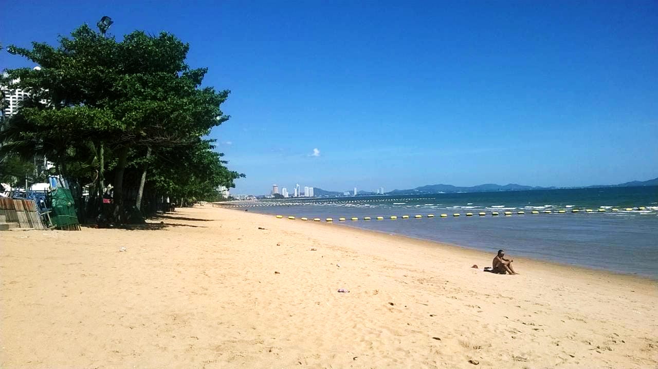 Quiet stretch of Jomtien Beach with soft sand and blue sky