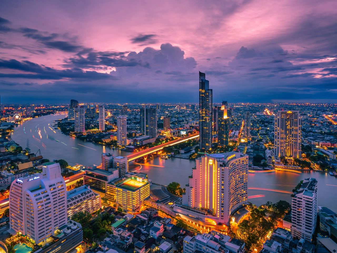 Bangkok skyline and the Chao Phraya river glowing at dusk